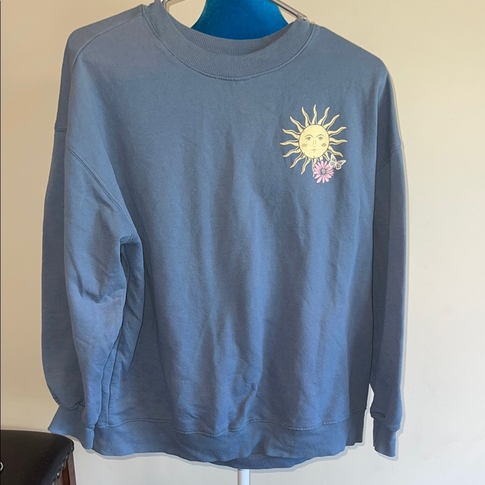 Rebellious One Blue Sweatshirt with Sun and Flower Design